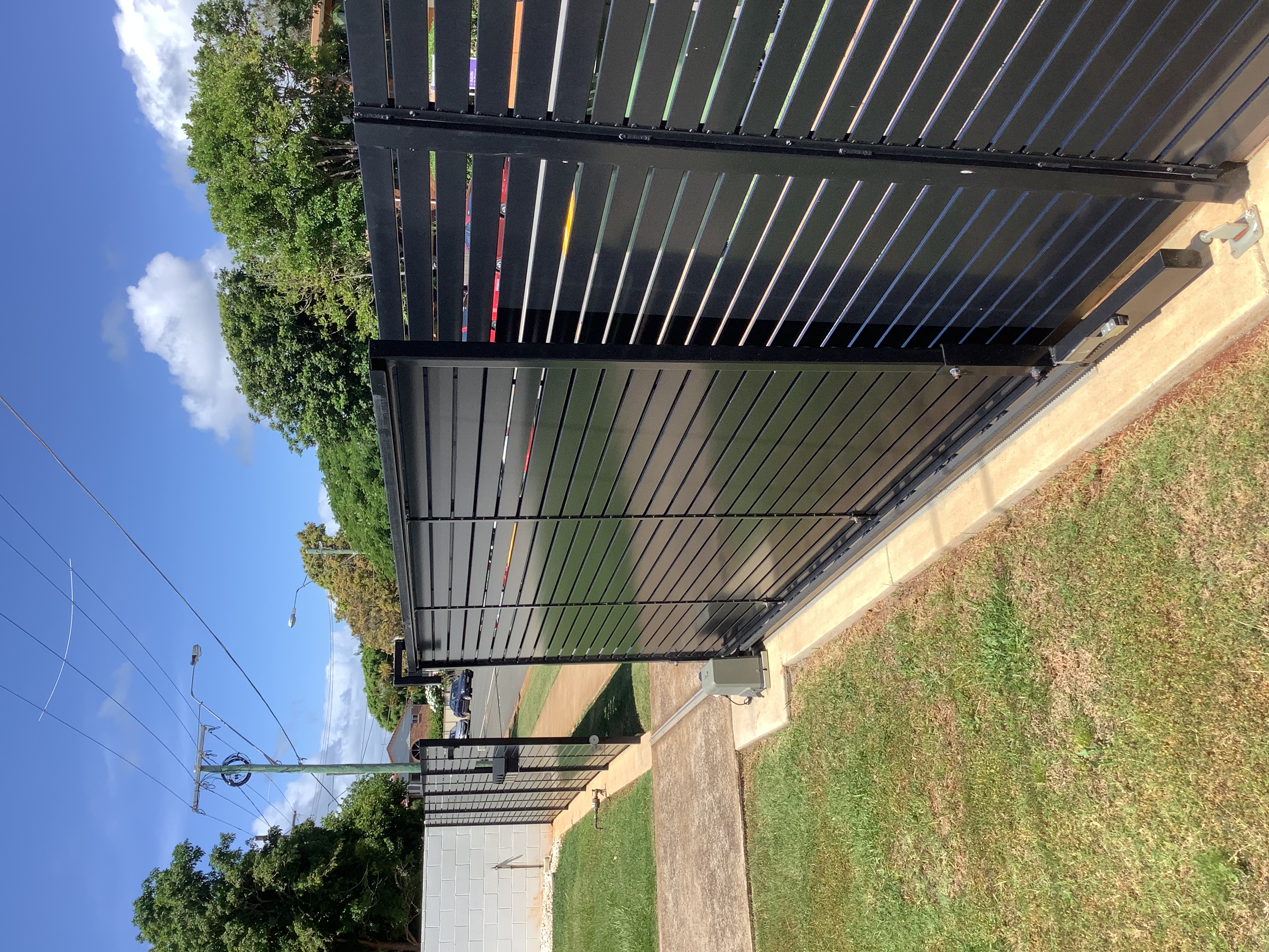 Dark grey vertical slat aluminium driveway gate at a North Lakes home - Gateflex, North Lakes