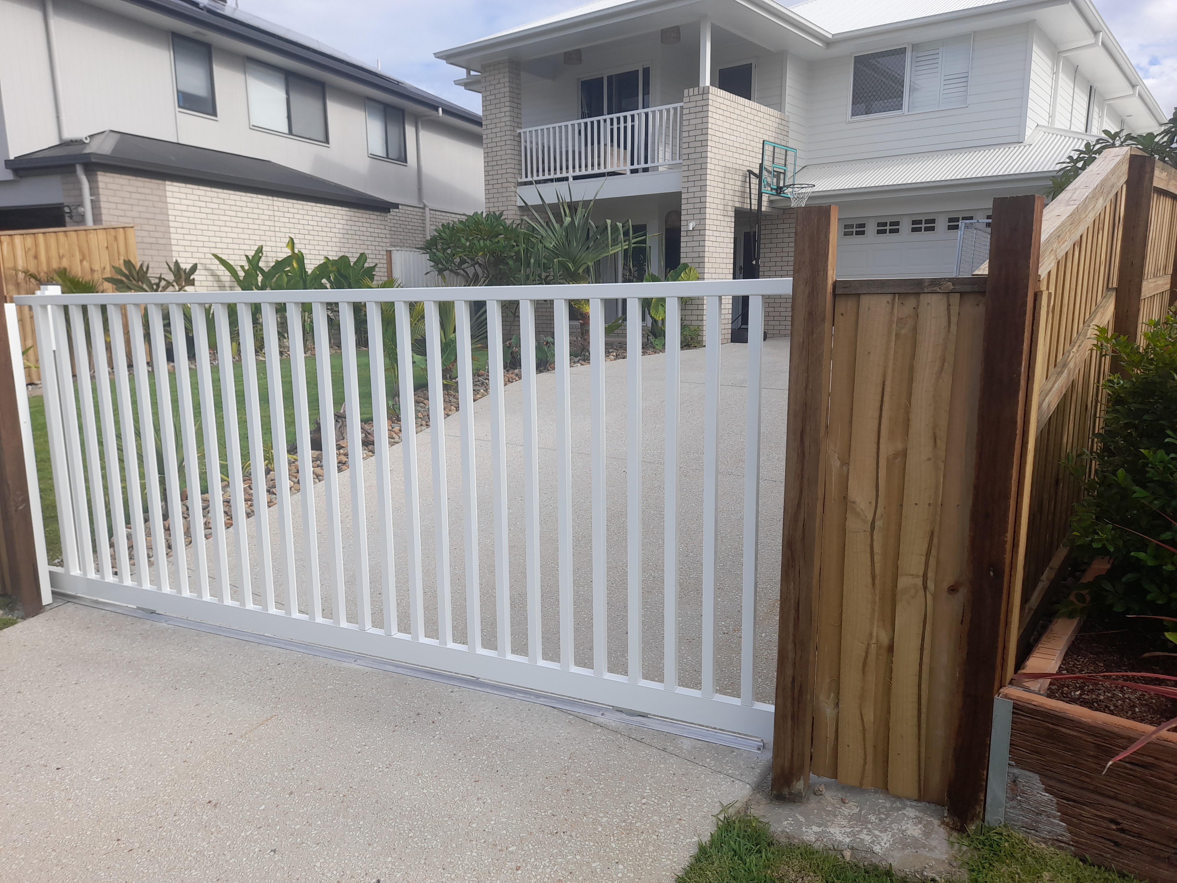 White aluminium panel fencing on a rendered retaining wall finished for handover - Gateflex, Caboolture