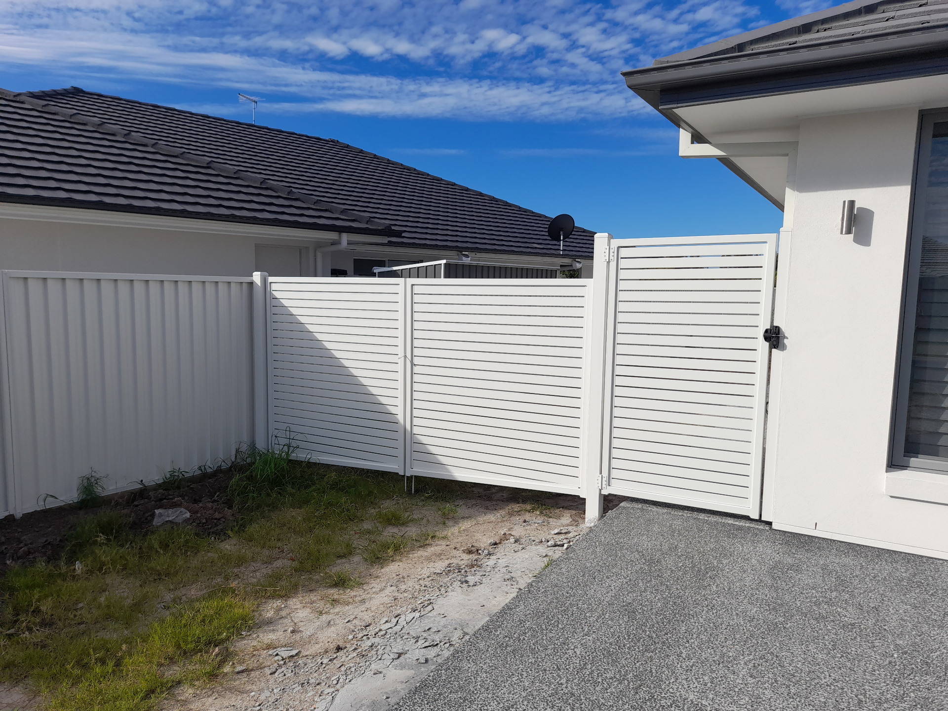 White horizontal slat aluminium gate and matching Colorbond fence panel installed at the side of a Burpengary home - Gateflex, Burpengary