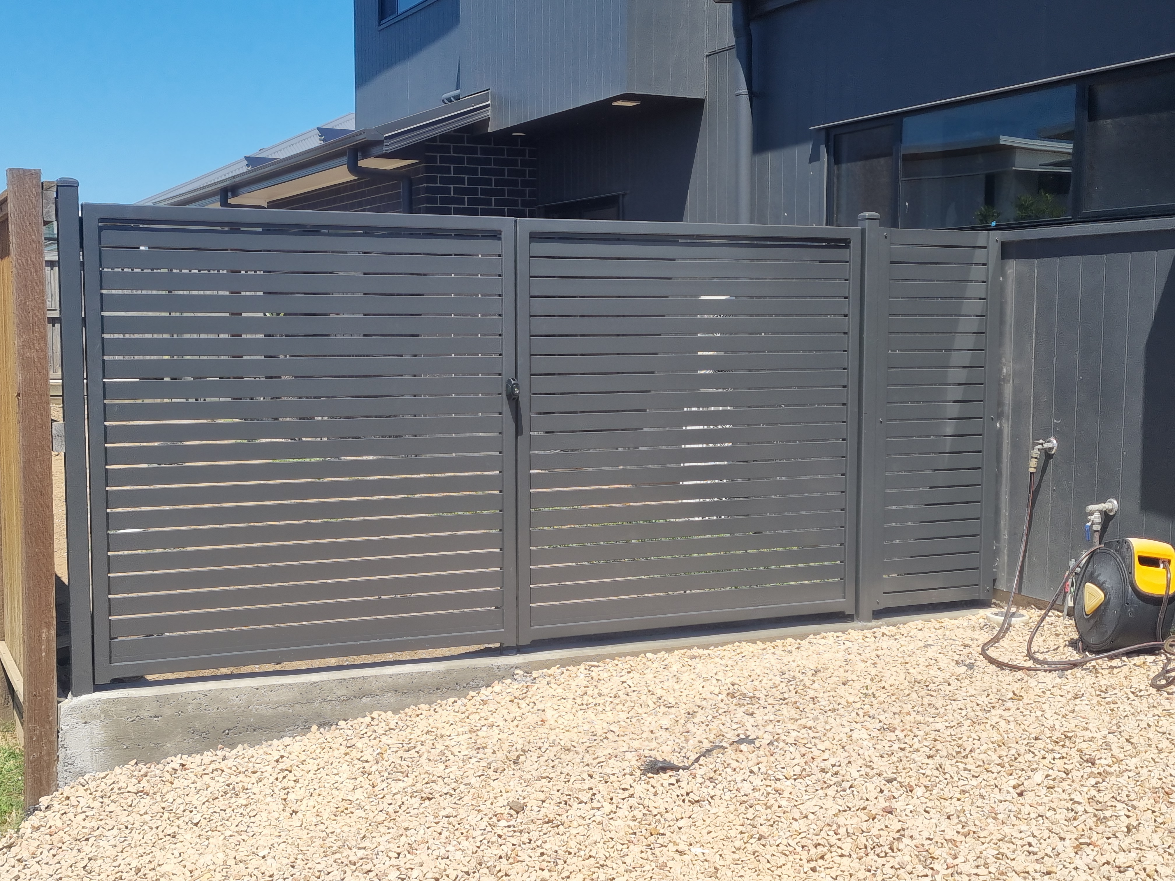 Black tubular driveway gate at a residential entrance - Gateflex, Caboolture