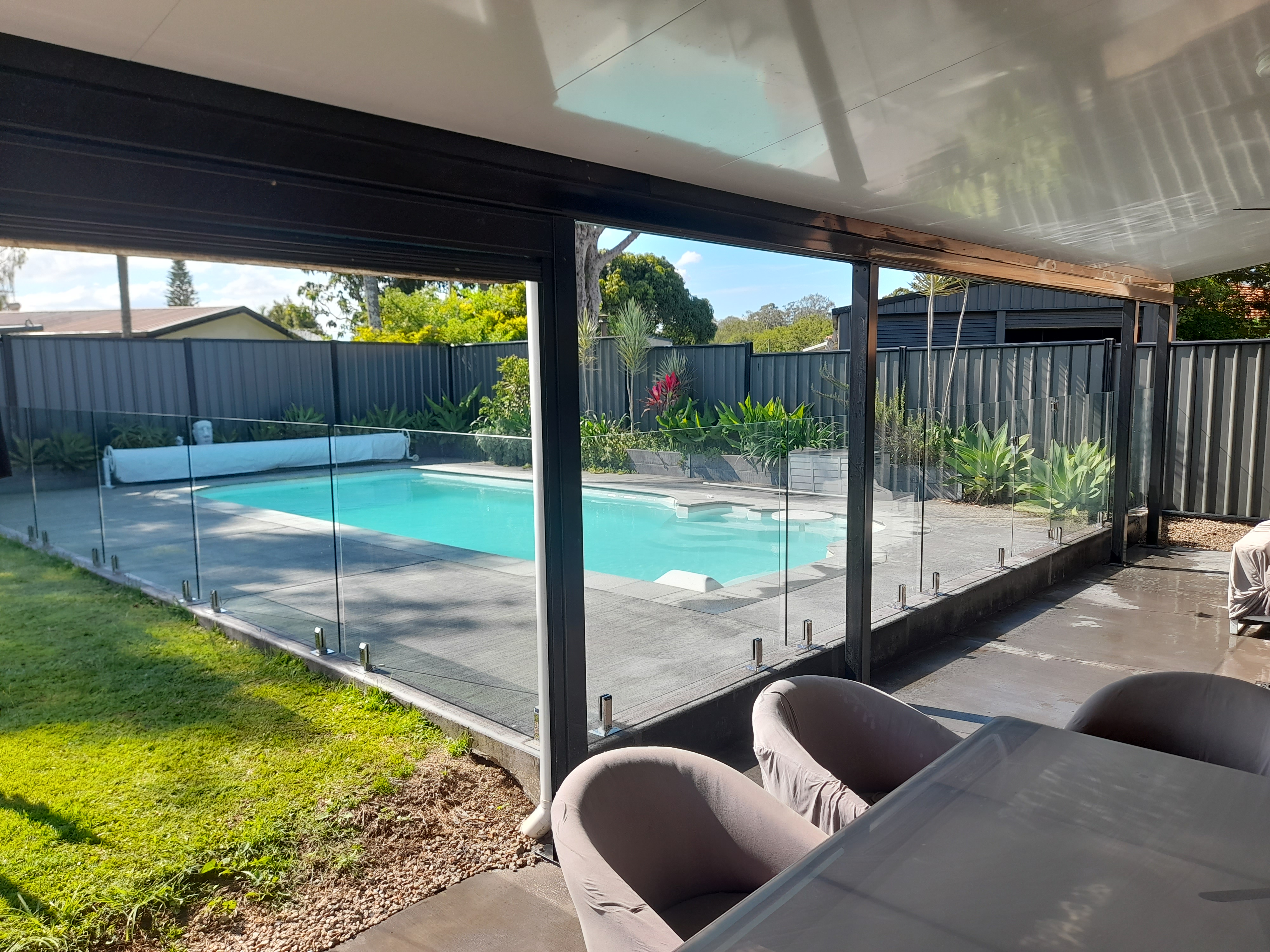 Frameless glass pool fencing around a backyard pool in Redcliffe - Gateflex, Redcliffe